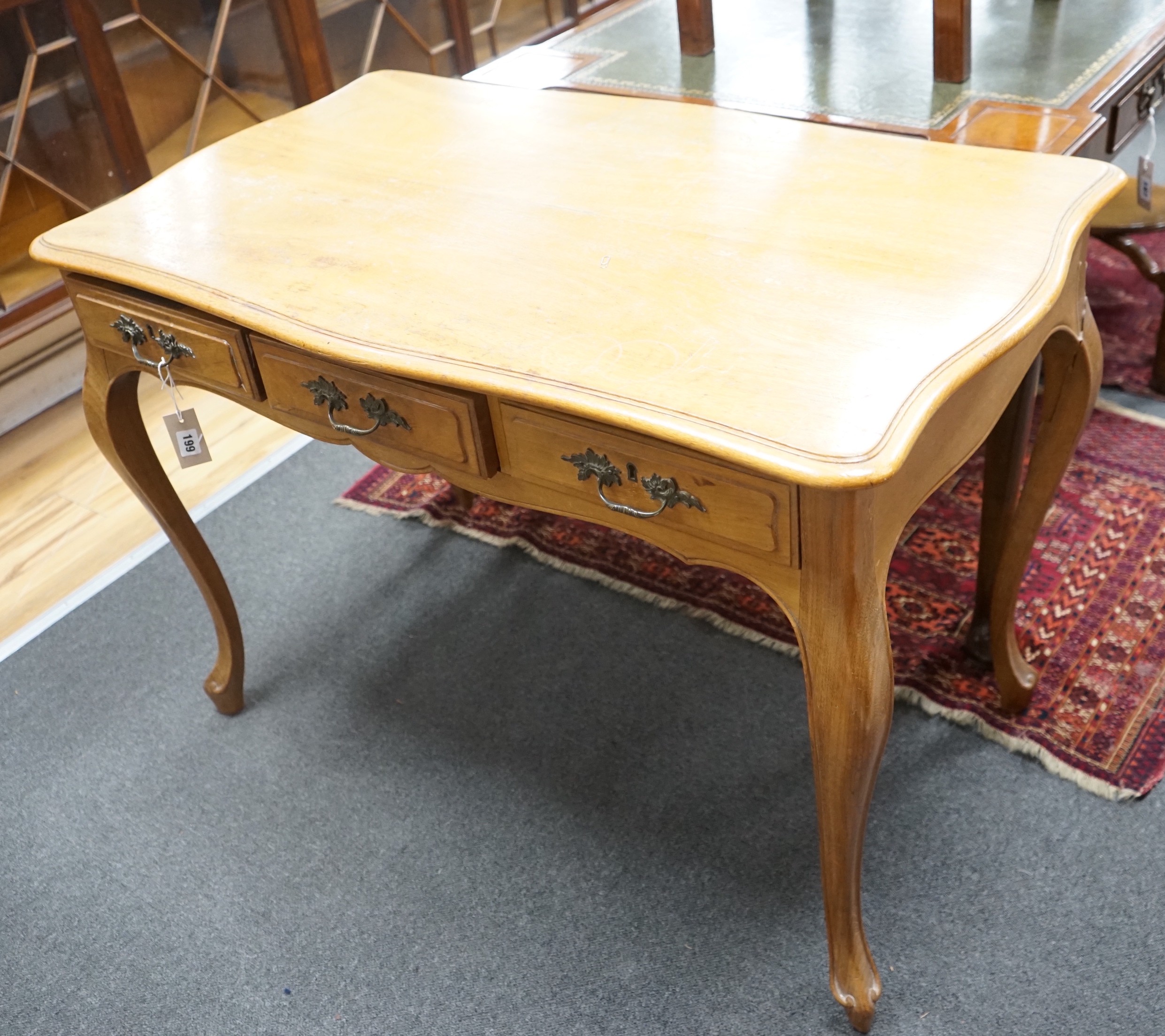 An early 20th century French serpentine three drawer side table, width 108cm, depth 62cm, height 76cm